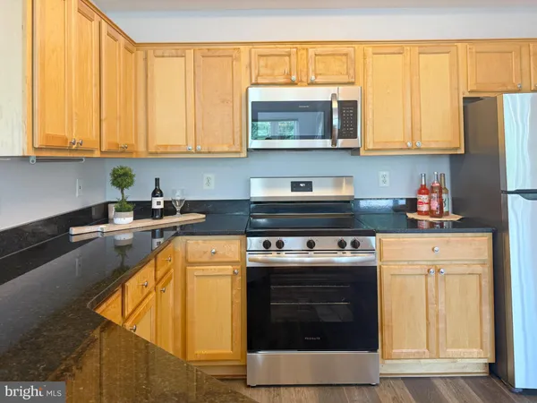 a kitchen with stainless steel appliances granite countertop a stove microwave and cabinets