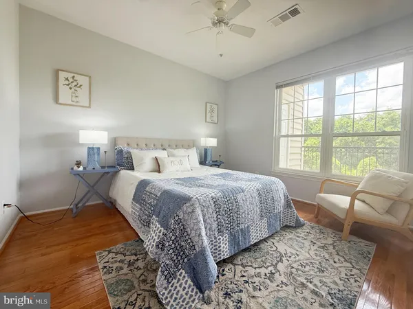 a bedroom with a bed rug and a large window