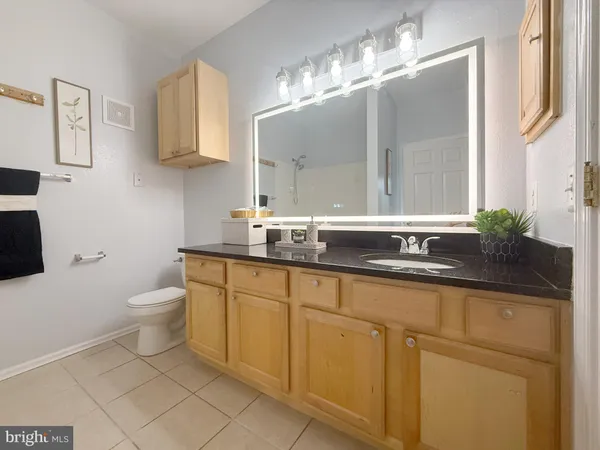 a bathroom with a granite countertop sink a toilet and mirror