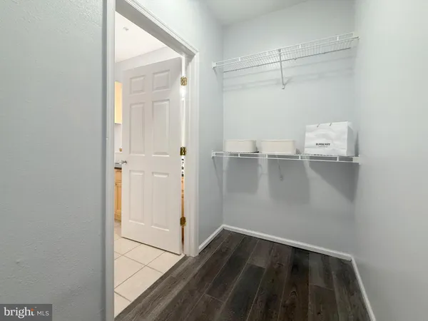 a view of a walk in closet with wooden floor