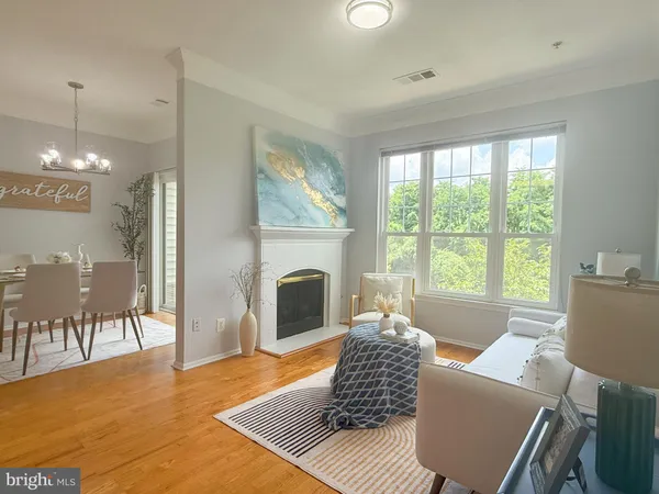 a living room with furniture a large window and a fireplace