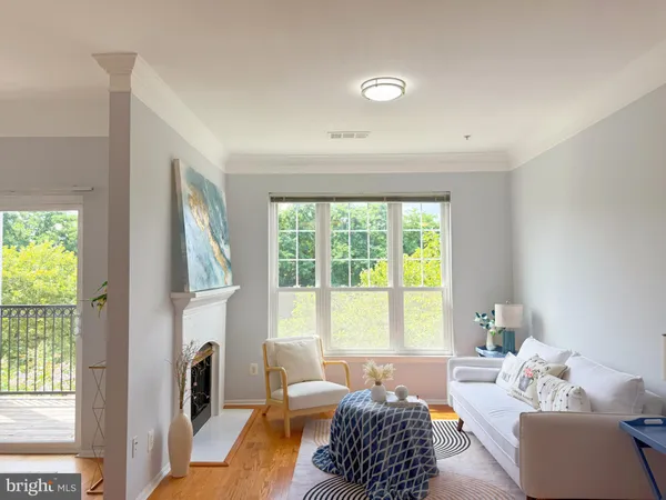 a living room with furniture a fireplace and a large window