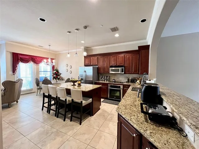 a kitchen with stainless steel appliances granite countertop a stove top oven a sink a counter space and cabinets