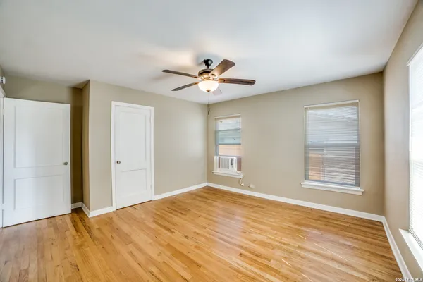 a view of an empty room with a window and a ceiling fan