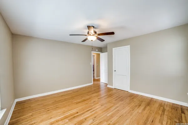 a view of a room with wooden floor and a ceiling fan