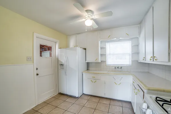 a kitchen with a sink a refrigerator and cabinets