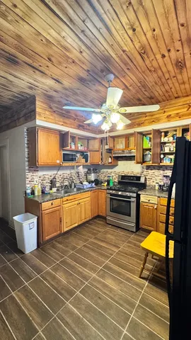 a kitchen with stainless steel appliances granite countertop a sink and wooden cabinets