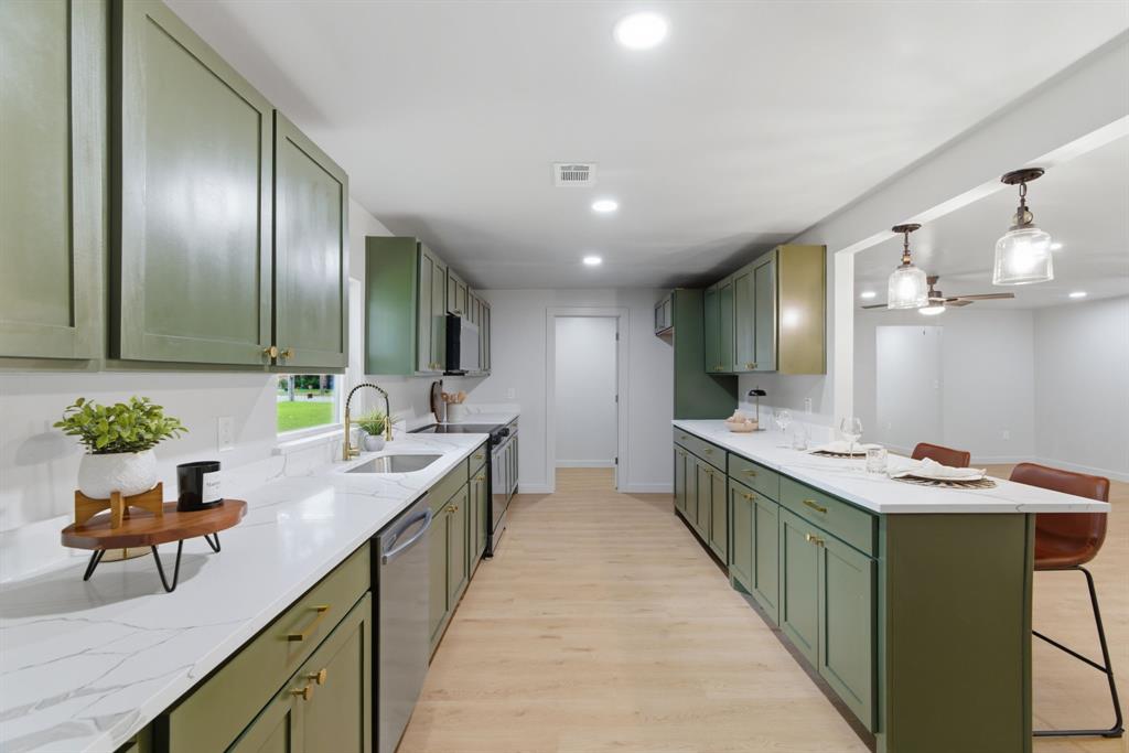 507 Country Club Road Cleburne, TX 76033 - Photo 12 of 39 Kitchen featuring extensive olive green cabinetry, light wood-finish flooring, recessed lighting, white countertops with veining, and a stainless steel dishwasher
