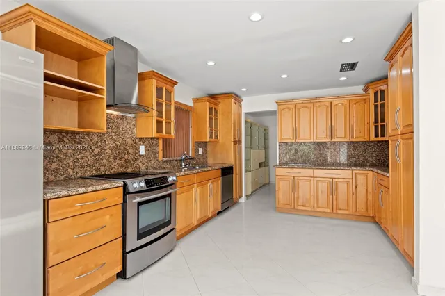 a large kitchen with stainless steel appliances granite countertop a stove and a refrigerator