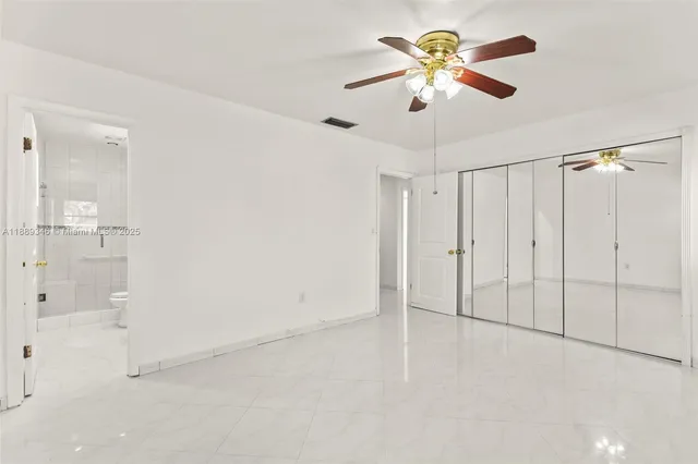an empty room with window and a ceiling fan