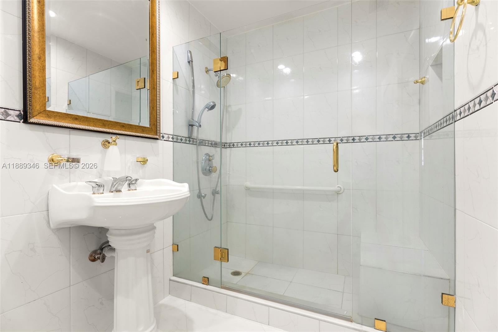 300 93rd Street Surfside, FL 33154 - Photo 29 of 34 a bathroom with a sink a mirror and a shower