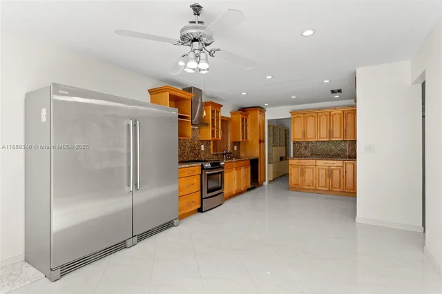 a view of a kitchen with a refrigerator and a stove top oven