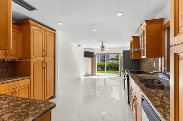 a kitchen with stainless steel appliances granite countertop a stove a sink and a refrigerator