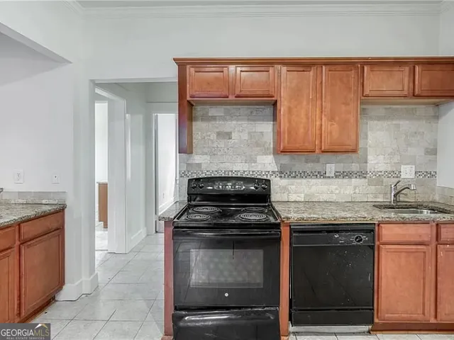 a kitchen with granite countertop a stove top oven cabinetry and granite counter tops