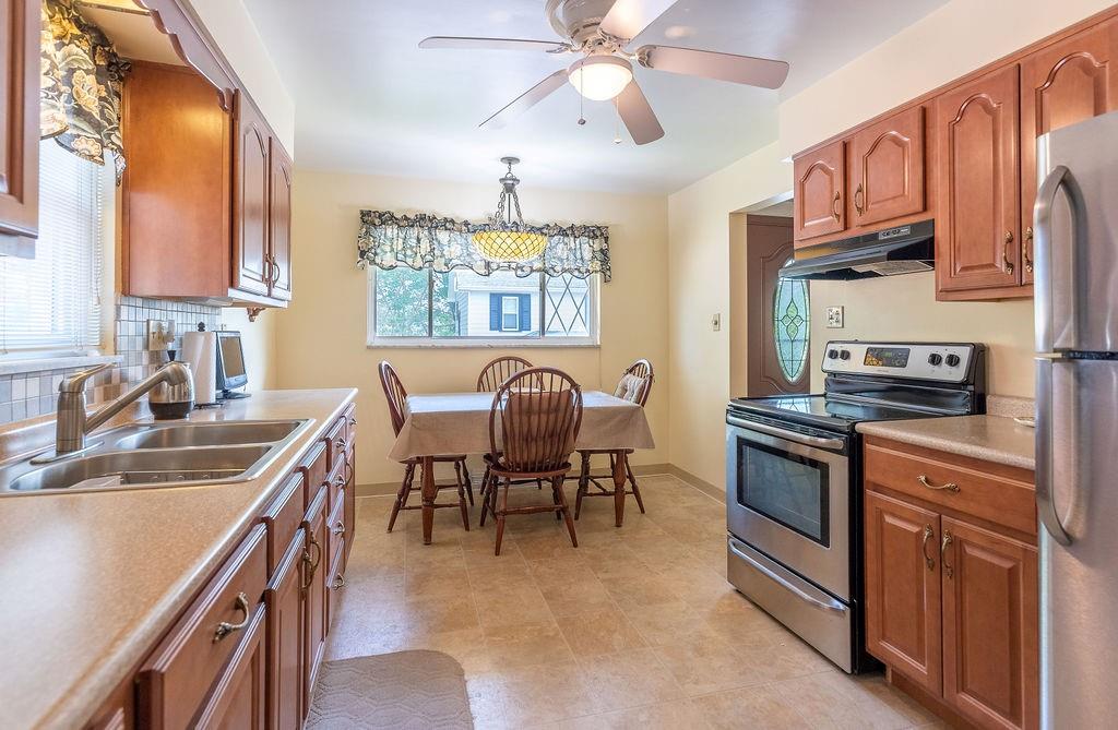 767 Virginia Avenue Rochester, PA 15074 - Photo 7 of 16 a kitchen with stainless steel appliances granite countertop a stove top oven a sink a dining table and chairs