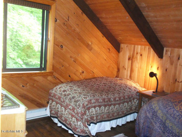 248 Stebbins Road Otis, MA 01253 - Photo 12 of 16 a bedroom with a bed and wooden floor