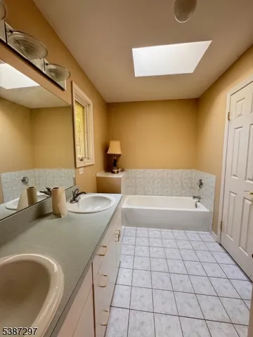 a bathroom with a granite countertop sink and a bathtub
