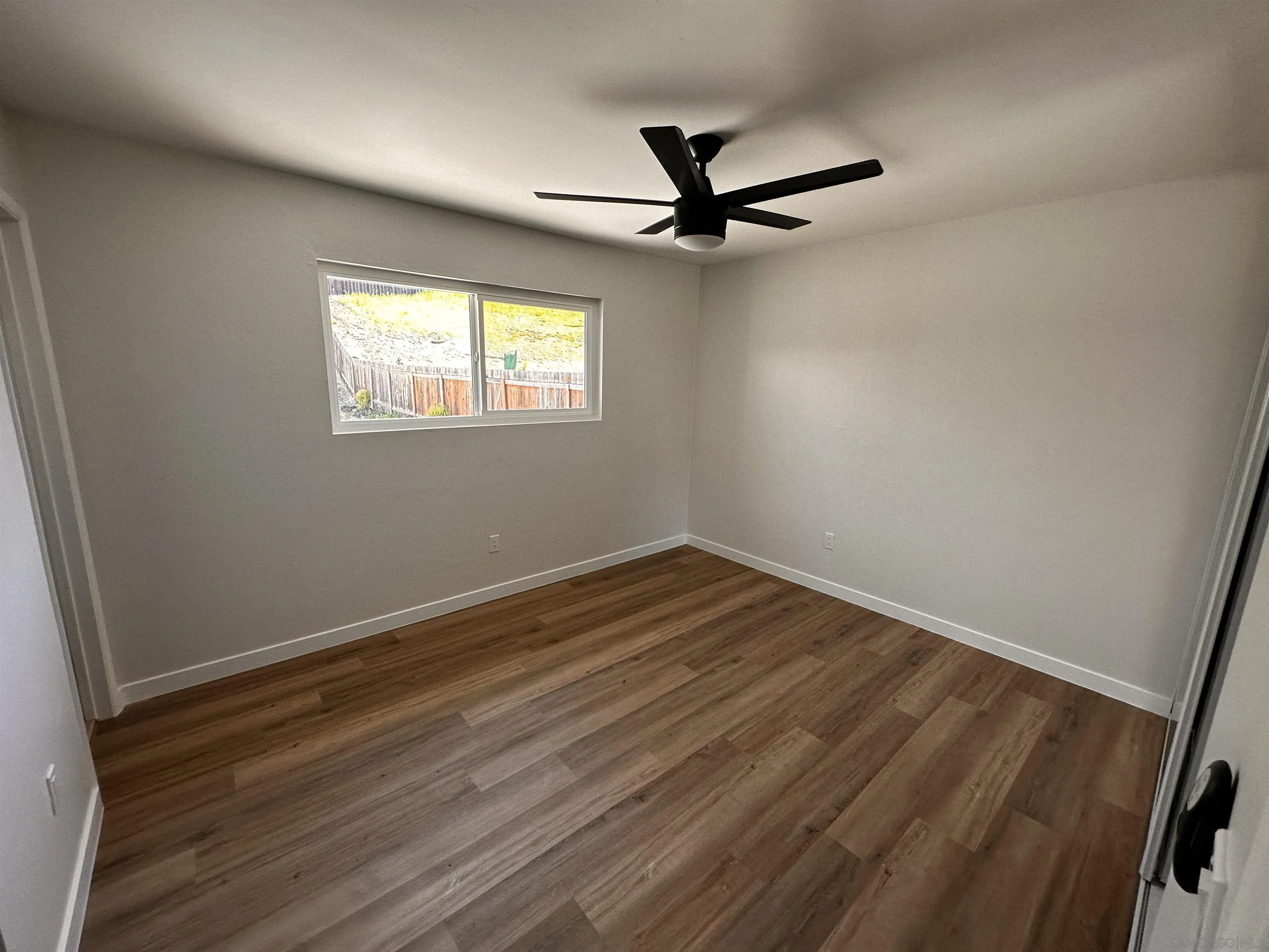 12733 McFeron Road Poway, CA 92064 - Photo 20 of 69 an empty room with wooden floor fan and windows