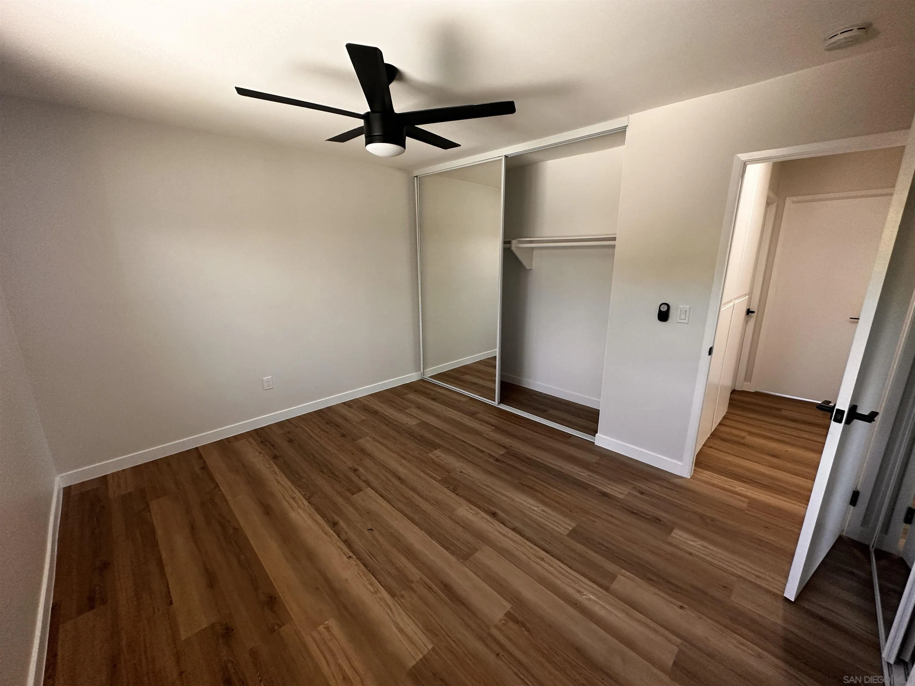 12733 McFeron Road Poway, CA 92064 - Photo 26 of 69 a view of a hallway with wooden floor and a ceiling fan
