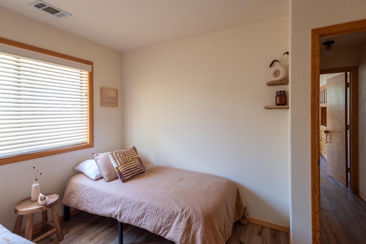34075 Shaver Springs Road Auberry, CA 93602 - Photo 16 of 38 a bedroom with a bed and wooden floor