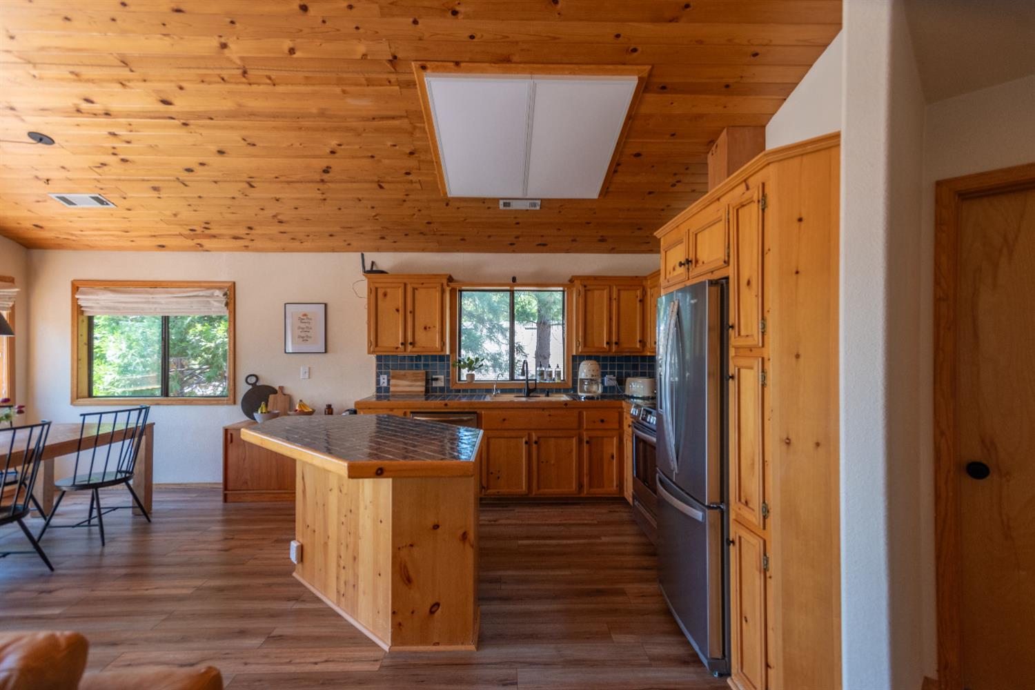 34075 Shaver Springs Road Auberry, CA 93602 - Photo 35 of 38 a kitchen with stainless steel appliances granite countertop a kitchen island wooden floors and white cabinets