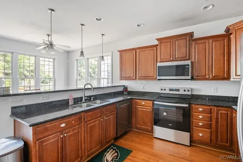 a kitchen with stainless steel appliances granite countertop a sink stove and refrigerator