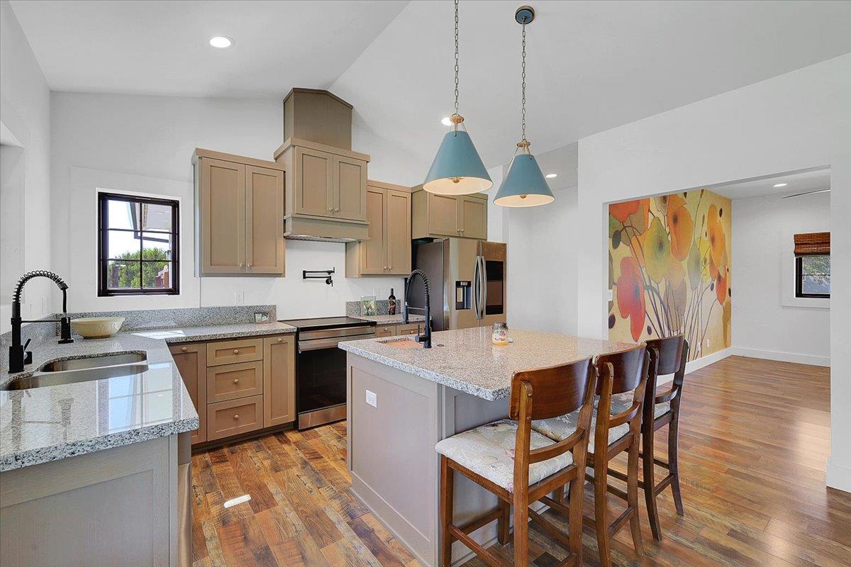 1102 Barry Road Yuba City, CA 95991 - Photo 52 of 88 a kitchen with stainless steel appliances granite countertop a kitchen island hardwood floor sink stove dining table and chairs