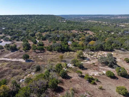 an aerial view of residential houses with outdoor space and trees
