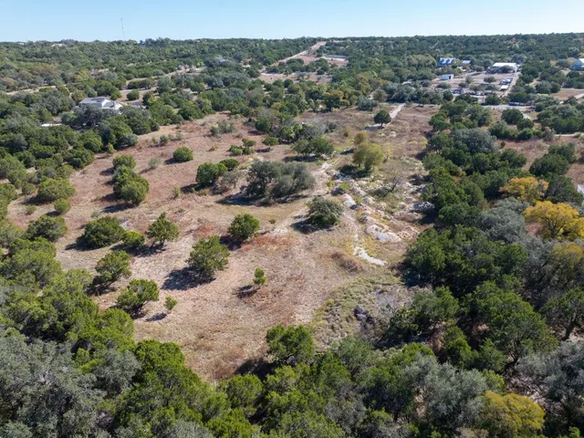 an aerial view of house with yard and mountain view in back