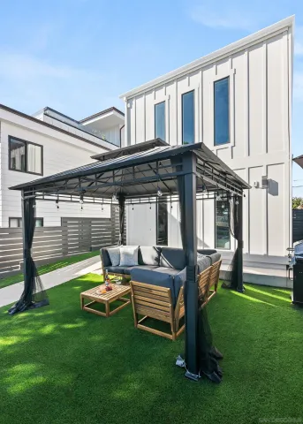 a backyard of a house with table and chairs