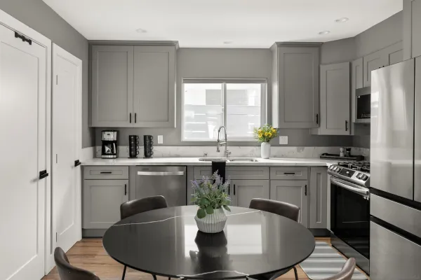 a kitchen with stainless steel appliances a sink a counter top space and a dining table