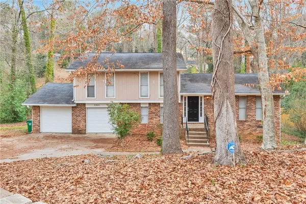 a front view of a house with a yard and tree s