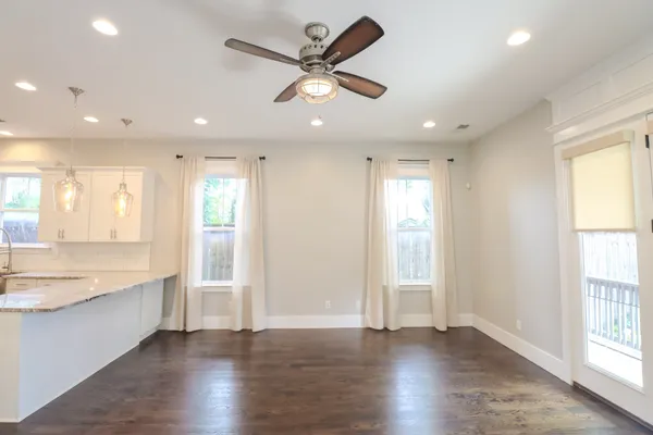 a view of an empty room with window and wooden floor