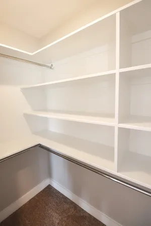 a view of walk in closet with empty racks