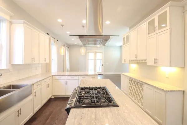 a large kitchen with granite countertop a large window a sink and stainless steel appliances