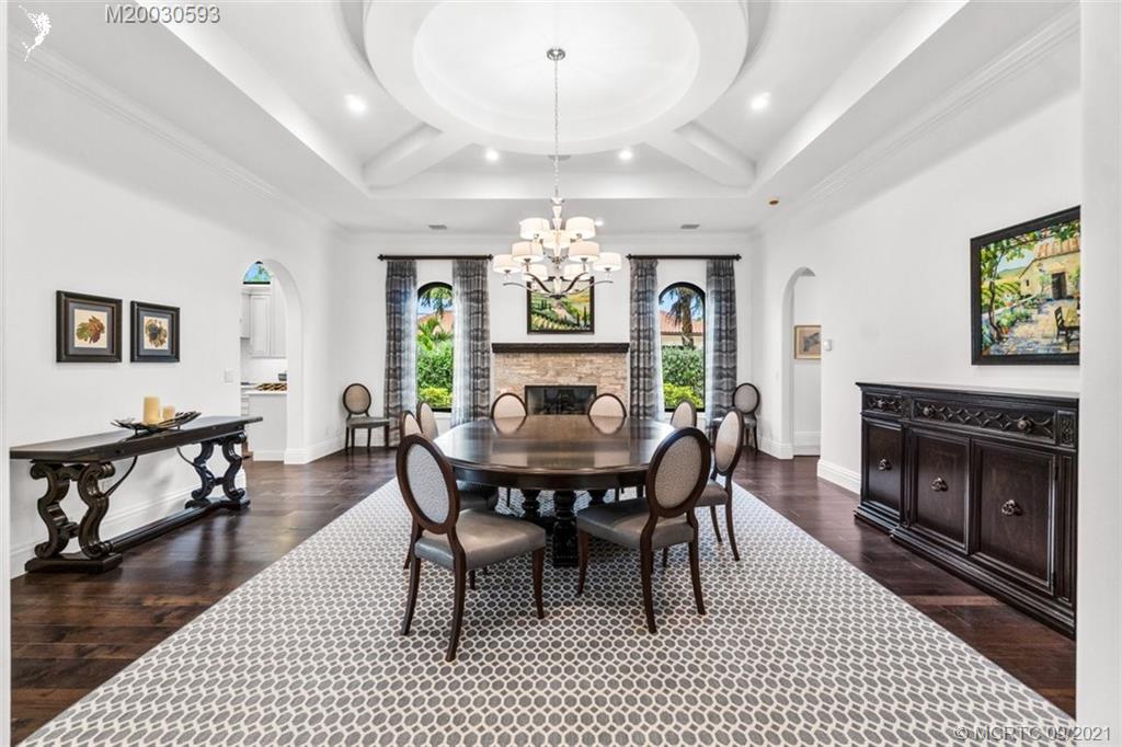1904 Southeast Sailfish Point Boulevard Stuart, FL 34996 - Photo 11 of 72 a dining room with furniture a rug a fireplace and a chandelier