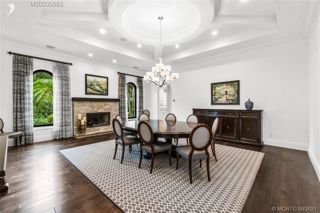 1904 Southeast Sailfish Point Boulevard Stuart, FL 34996 - Photo 12 of 72 a dining room with furniture a chandelier and wooden floor