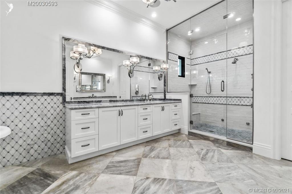 1904 Southeast Sailfish Point Boulevard Stuart, FL 34996 - Photo 24 of 72 a large bathroom with a granite countertop sink mirror and shower