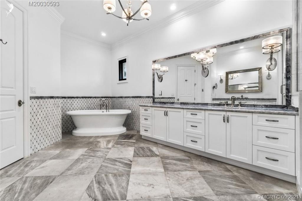 1904 Southeast Sailfish Point Boulevard Stuart, FL 34996 - Photo 25 of 72 a spacious bathroom with a double vanity sink a mirror and a bathtub