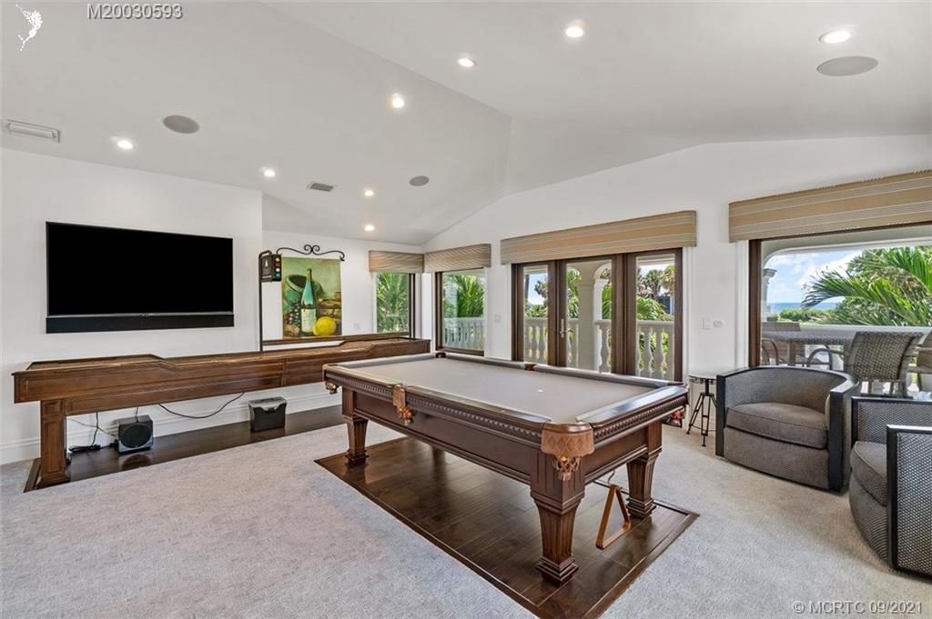 1904 Southeast Sailfish Point Boulevard Stuart, FL 34996 - Photo 32 of 72 a living room with pool table flat screen tv and windows