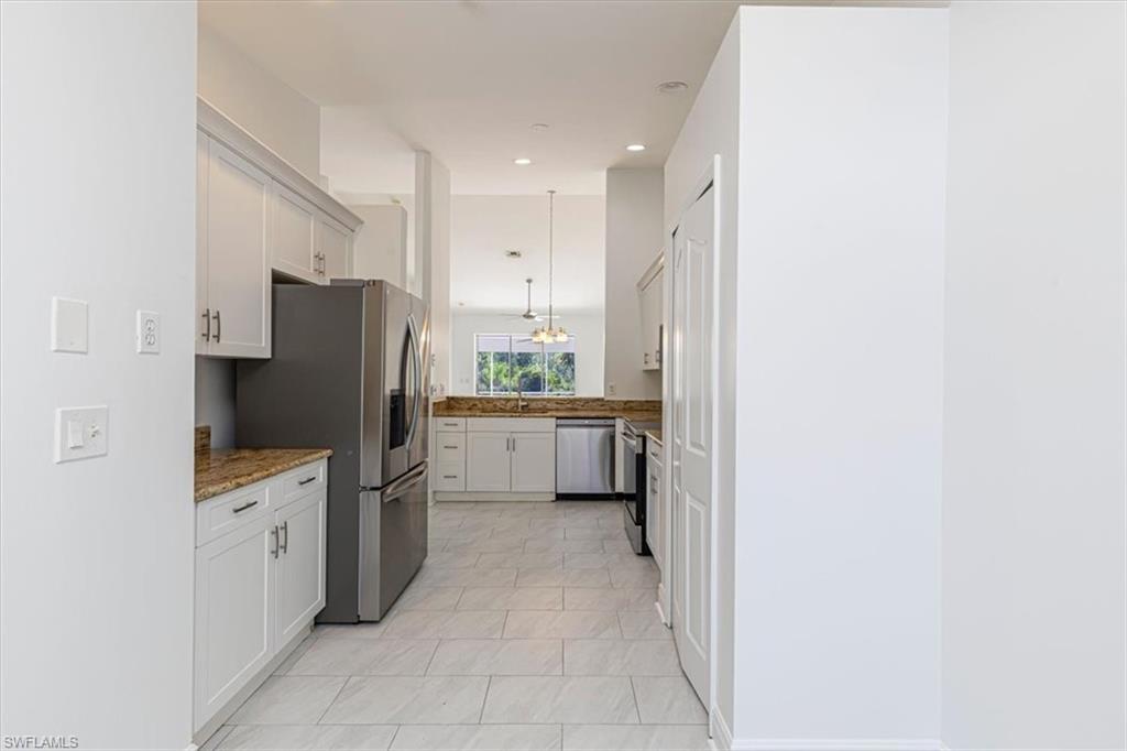 5446 Whitten Drive, Unit 19 Naples, FL 34104 - Photo 14 of 24 a kitchen with a refrigerator sink and stove
