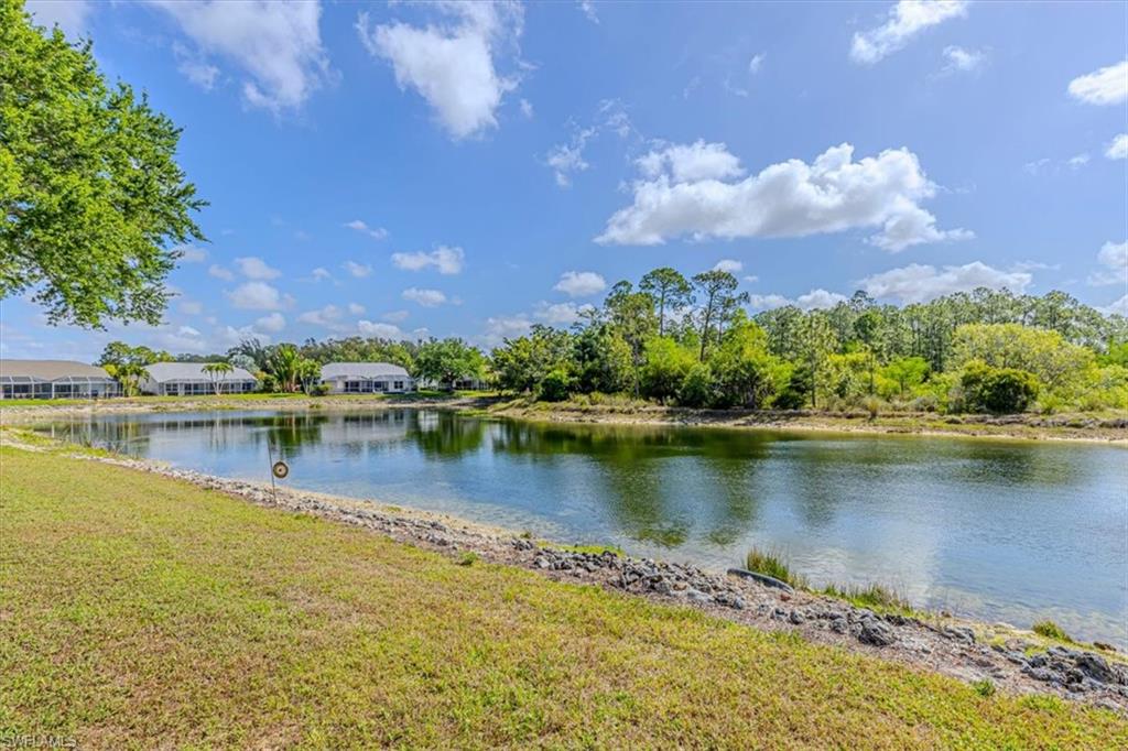 5446 Whitten Drive, Unit 19 Naples, FL 34104 - Photo 24 of 24 a view of a lake with a building in the background