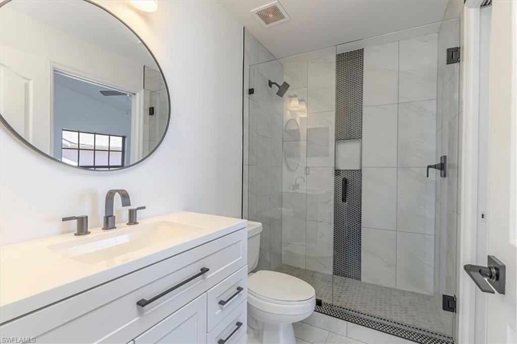 5446 Whitten Drive, Unit 19 Naples, FL 34104 - Photo 7 of 24 a bathroom with a sink a toilet and shower