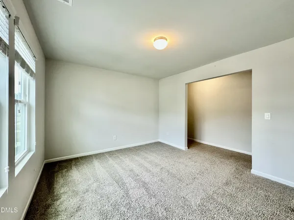 an empty room with an entryway and window