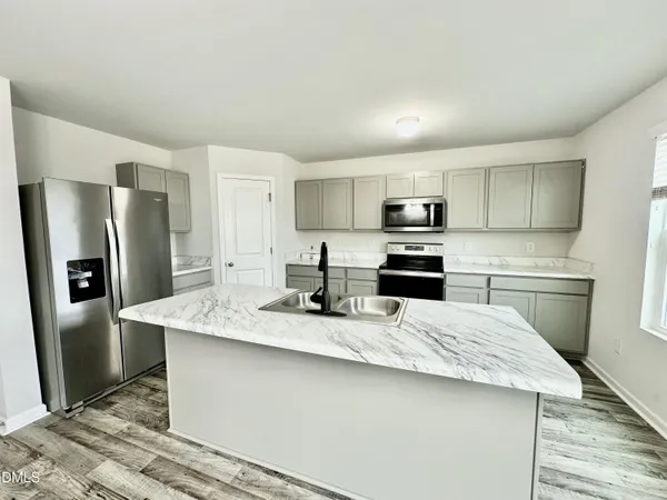a kitchen with stainless steel appliances granite countertop a refrigerator stove a sink and dishwasher