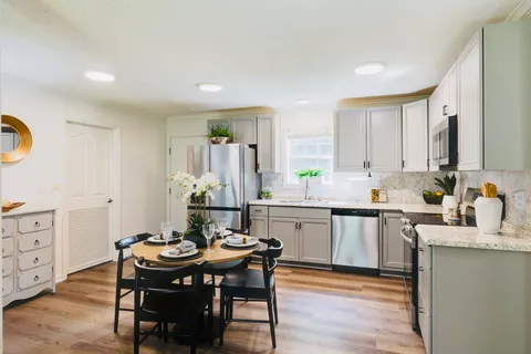 a kitchen with granite countertop a sink and white appliances