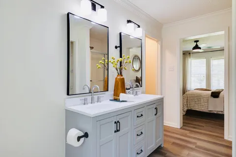 a bathroom with double vanity and a mirror