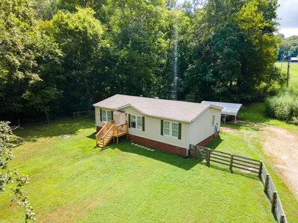an aerial view of a house with swimming pool and garden