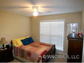 93 Morning Mist Road Fletcher, NC 28732 - Photo 9 of 12 a bedroom with a bed and a table in it
