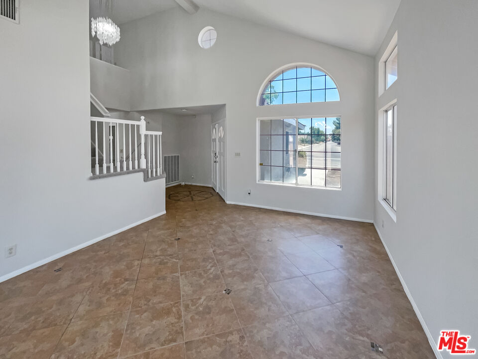 1615 East Kettering Street Lancaster, CA 93535 - Photo 6 of 15 an empty room with windows and fan